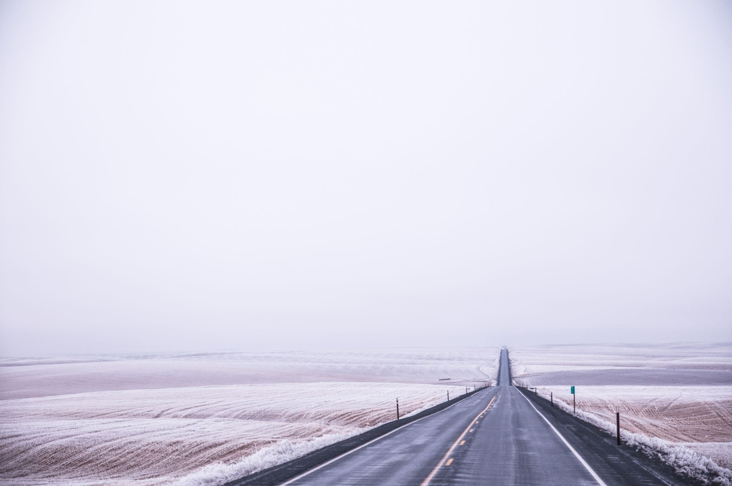 Windshield replacement Delisle area: straight two-lane highway through frosted, snow-dusted prairie fields