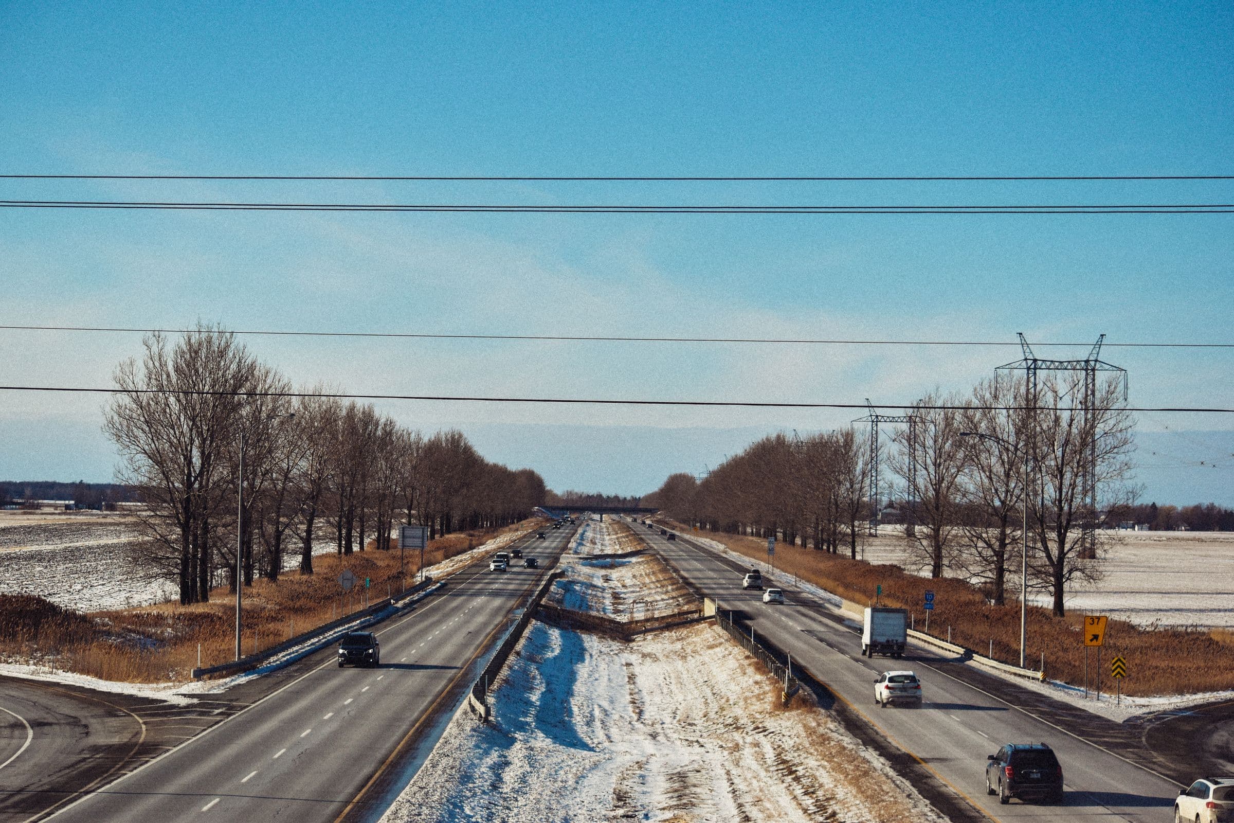 Windshield replacement Dundurn area: divided highway with light traffic through snowy farmland on a clear winter day