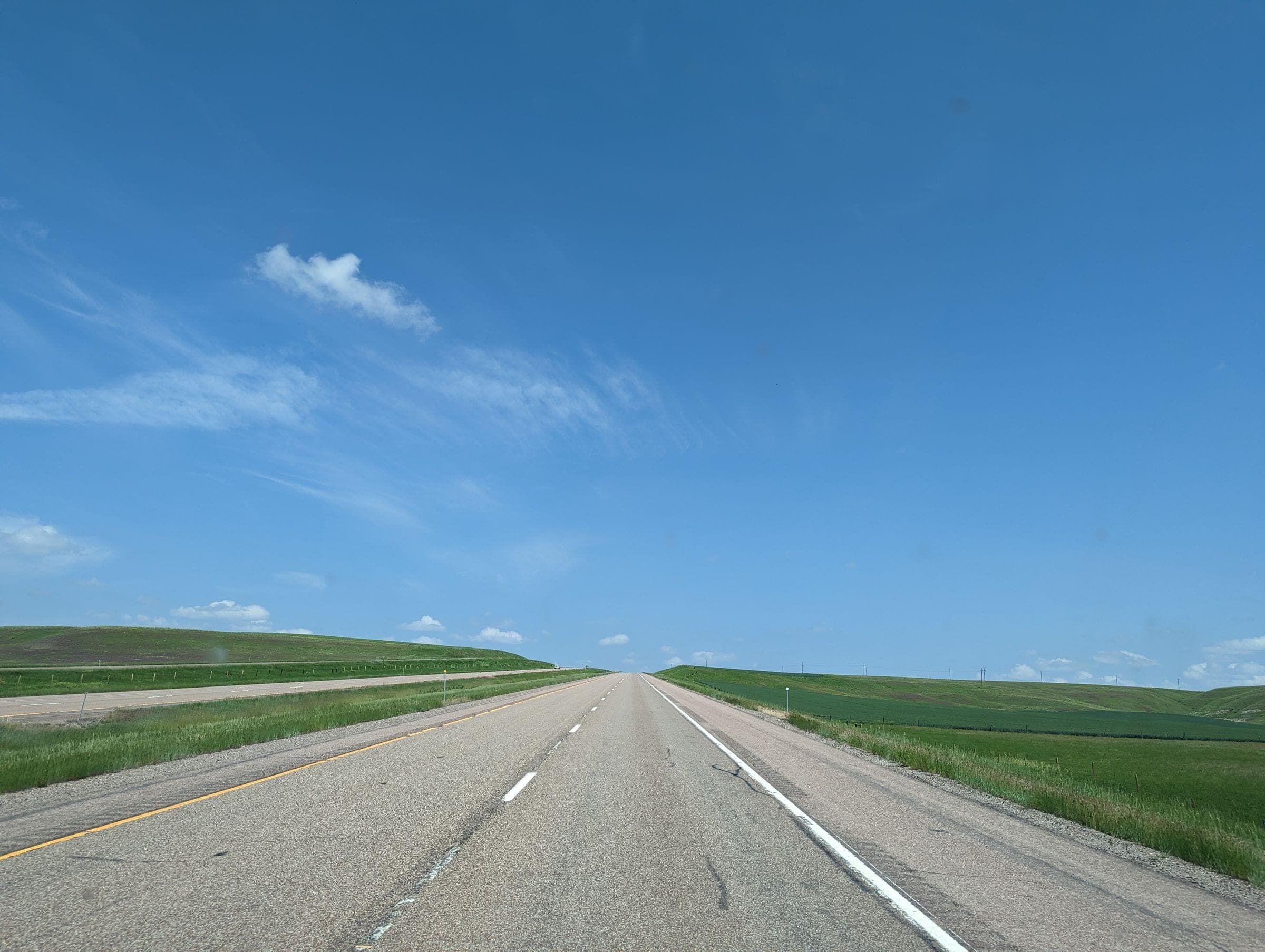 Windshield replacement Warman area: twinned prairie highway running straight between green fields under a blue sky